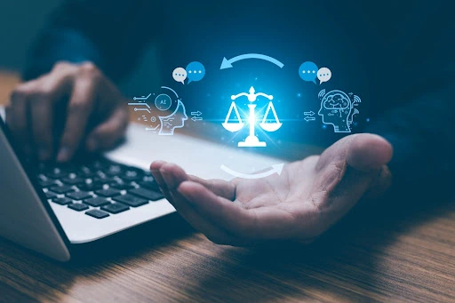 Holographic scales of justice between two outlined heads, hovering above an open laptop and a person's hands.
